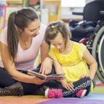Caregiver Reading a Book with a Mentally Disabled Child