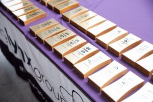 Photo: Two rows of gold-tone awards, with text, lying face-up on a purple tablecloth