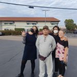 DRLC client Avirmed on a residential street with three people standing close to him after his release from ICE
