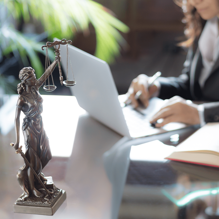 Lady Justice with laptop and book symbolizing DRLC disability justice.