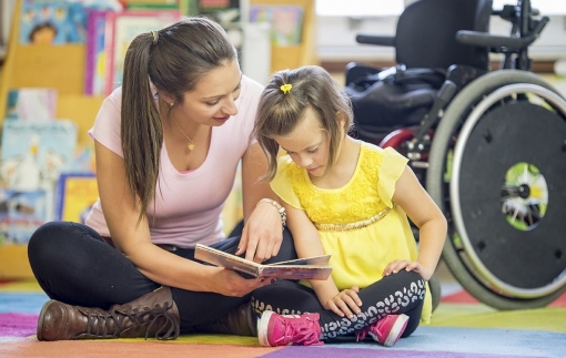 Caregiver Reading a Book with a Mentally Disabled Child